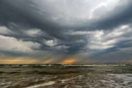 Donkere wolk van naderende hagelbui boven de Noordzee tijdens storm op het Kennemerstrand bij IJmuiden.