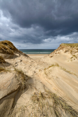 Donkere wolken boven een grote kerf in de zeeduinen van het Noordhollands Duinreservaat op het strand van Heemskerk.