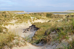 Uitzicht over de Slufter vanaf een zanderige, met helmgras begroeide duintop in het Nationaal Park Duinen van Texel bij De Cocksdorp.