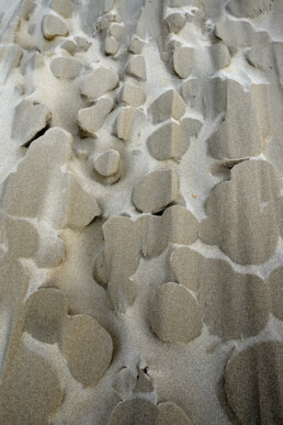 Uitgeslepen zandvormen in een groot stuifgat in de duinen na een storm op het strand van Heemskerk