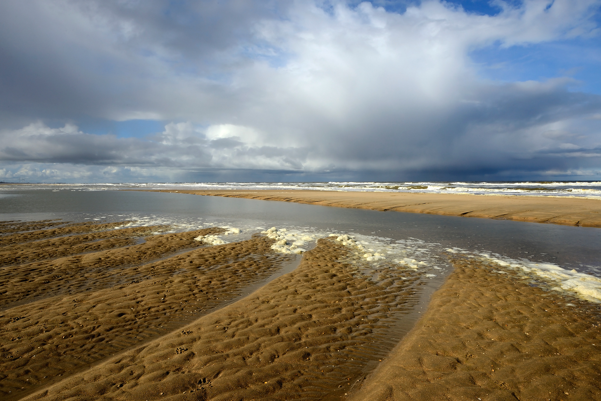 Dreigende wolkenlucht van naderende, grote hagelbui boven zee op het strand van Castricum aan Zee