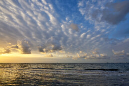 Zonsopkomst op het waddeneiland Texel met warm licht en mooie wolkenlucht boven de Waddenzee.