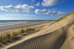 Uitzicht over het strand en de Noordzee op een zonnige winterdag vanaf een duinhelling in de zeereep op het strand van Heemskerk.