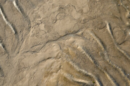 Lijnen en patronen in het zand en slik tijdens laagwater op het strand van de Kwade Hoek in de Duinen van Goeree.