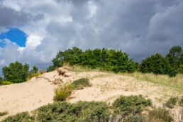 Wolkenlucht boven zanderige duinhelling van een stuifkuil in de Amsterdamse Waterleidingduinen bij Zandvoort.